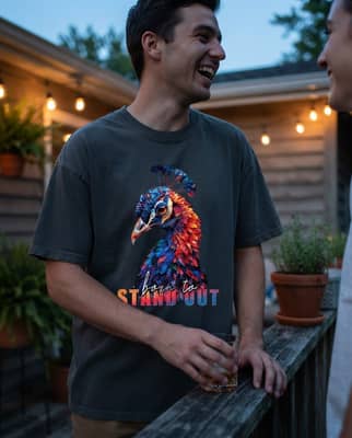 A person in a dark wolf tee laughs on a porch at dusk with warm string lights behind them.